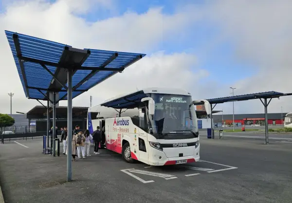 Autobus Aerobus na przystanku lotniskowym, z pasażerami wsiadającymi.